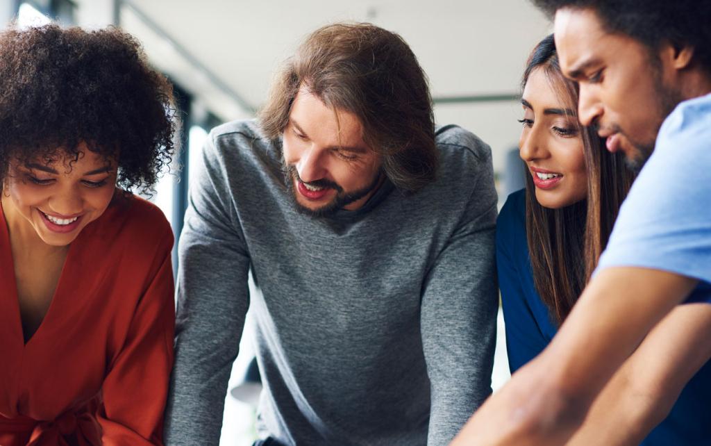 Group of people looking down together at a plans on a table